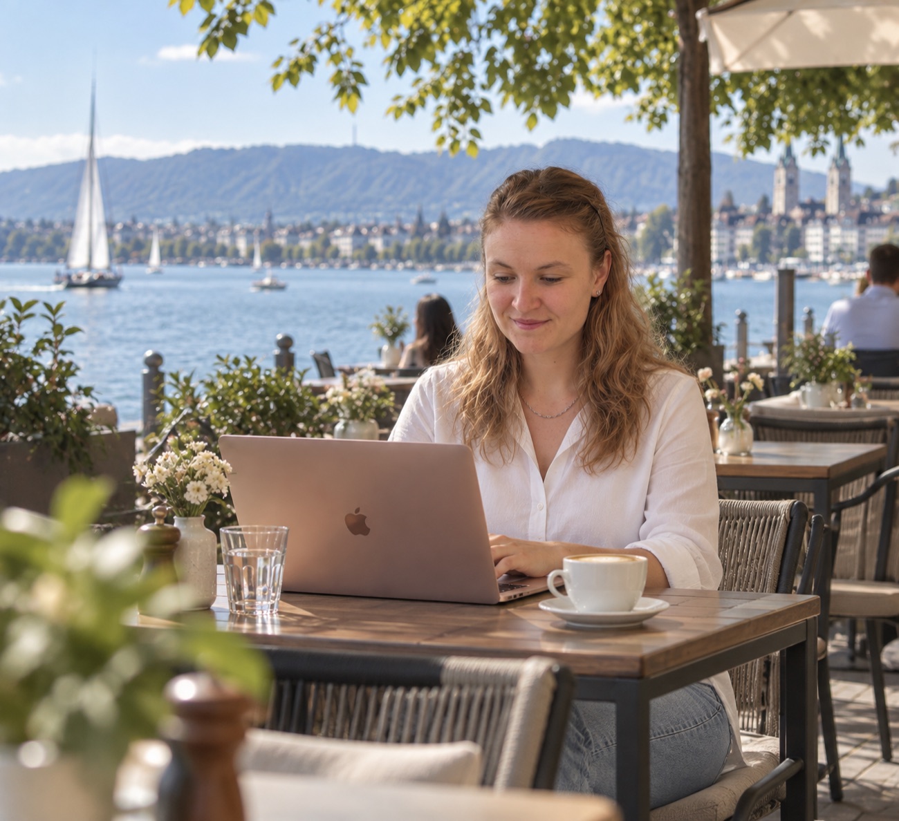 Charis Schoppe arbeitet am Laptop mit Blick auf den Zürichsee
